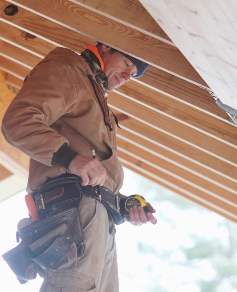 Team member of Lotus Building Group on top of a roof that's being remodeled. Contact Lotus Building Group as your custom home renovation contractor in Nashville, TN. 