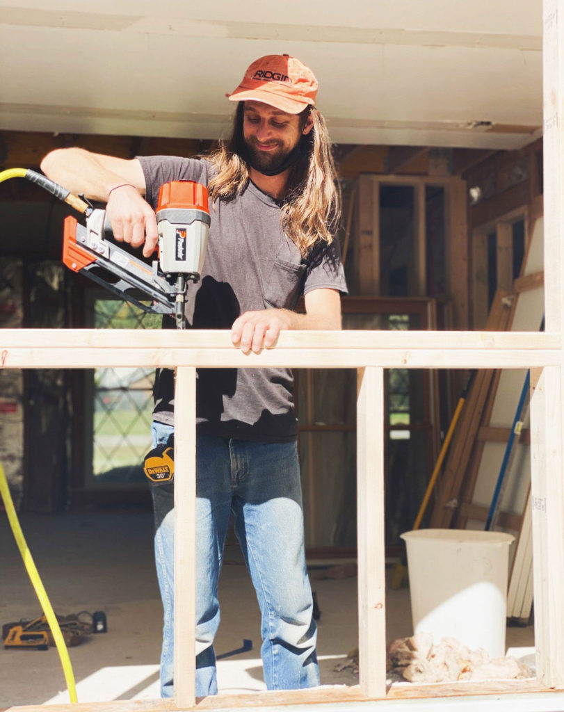 Team member of Lotus Building Group on top of a roof that's being remodeled. Contact Lotus Building Group as your custom home renovation contractor in Nashville, TN. 