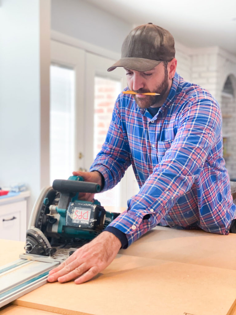 Lotus Building Group team member David in the process of measuring wood for a project. 