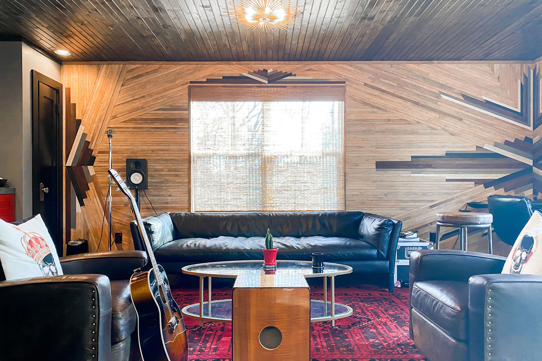 Home renovation project of a speakeasy styled studio. This studio features stylized wood walls, dark flooring and leather accent furniture. Contact Lotus Building Group as your custom home renovation contractor in Nashville, TN.