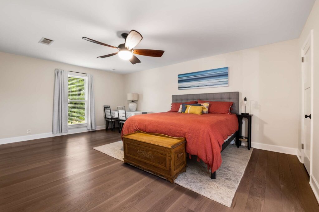 23 Residential guest bedroom renovation project. This bedroom features wood flooring, cream walls and wooden accent furniture. Contact Lotus Building Group as your home renovation contractor in Nashville, TN.
